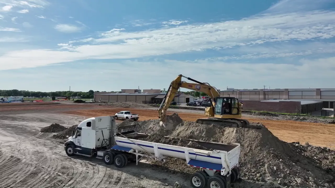 Excavator loading mixed dirt and rock for export on the Urban Garages development in Melissa, Texas