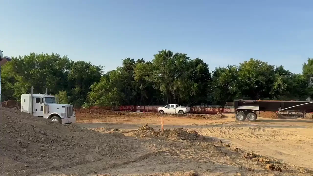 A dump truck delivering fill dirt on a residential street in Southlake, Texas